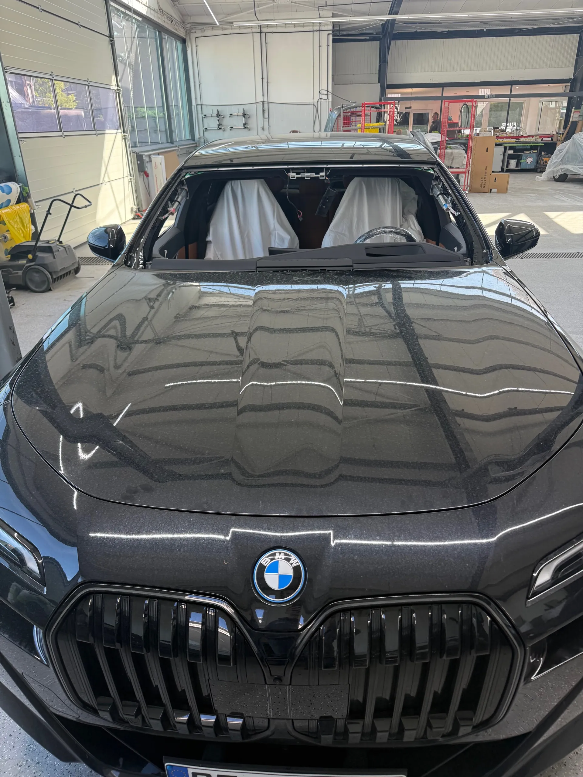 BMW in der Werkstatt mit ausgebauter Frontscheibe.