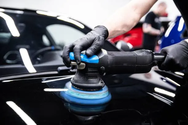 Politur von schwarzem Autolack mit einer Poliermaschine.