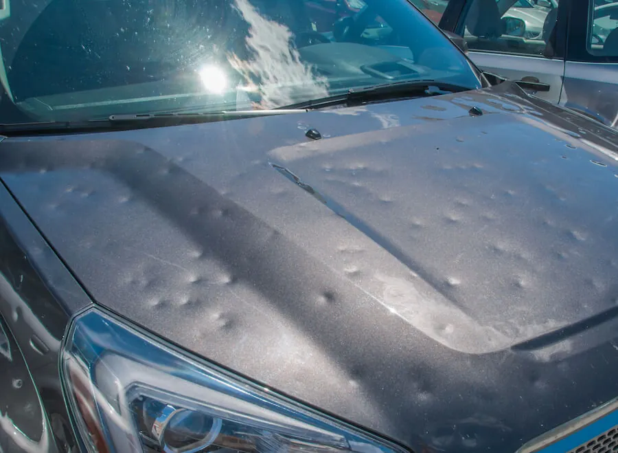 Motorhaube mit zahlreichen Dellen durch Hagelschaden.