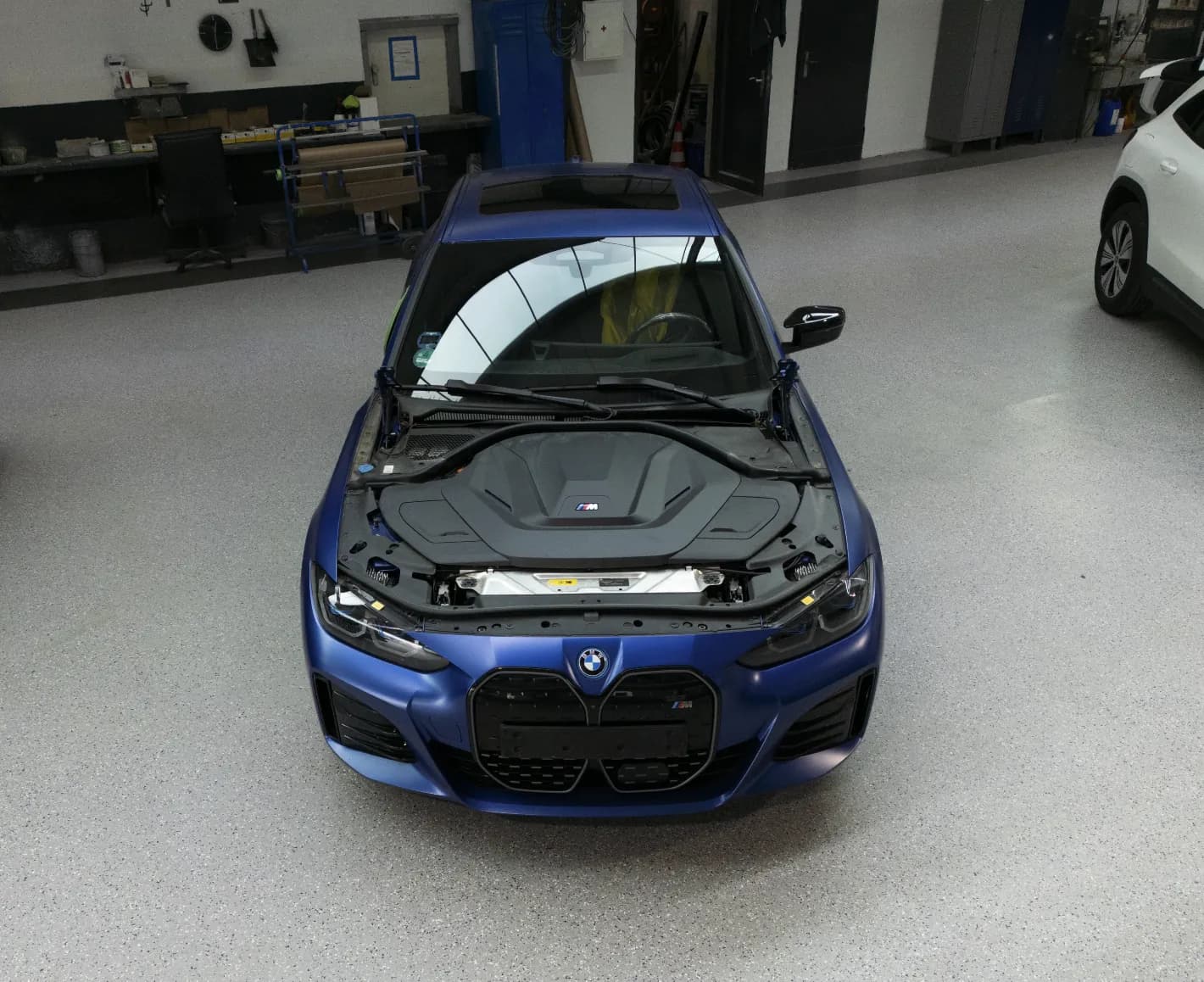 Blauer BMW mit geöffneter Motorhaube in der Werkstatt der Fuhr GmbH.